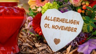 Grab mit Blumenschmuck und Grableuchte, Herz mit Aufschrift Allerheiligen, 1. November   