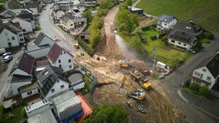 Mit schwerem Gerät wird an der Ahr der Wiederaufbau der Bahnstrecke vorangetrieben. 