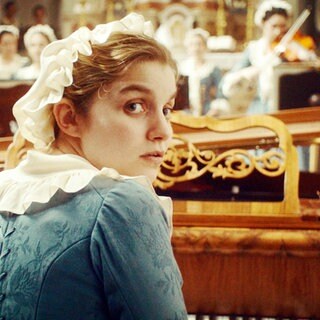 Filmszene "Gloria!": Teresa (Galatéa Bellugi) sitzt am Pianoforte und dreht sich zum Betrachter hin