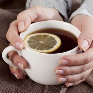 Eine Frau hält eine Tasse Tee