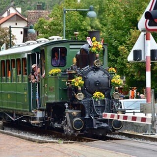 Die reich geschmückte Lok an einem der vielen Bahnübergänge.