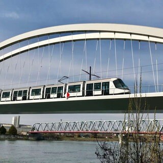 Eine Straßenbahn fährt auf der Beatus Rhenanus Brücke über den Rhein von Straßburg nach Kehl.