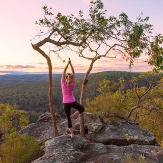 Frau macht Pilates auf dem Berg