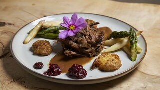 Pulled Beef mit Quetschkartoffeln auf einem Teller