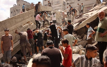 Palestinians search for survivors amids the rubble of a building, which collapsed after Israeli bombardment on a building adjacent to it, in the Sheikh Radwan neighbourhood in Gaza City