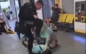 A still from a video appearing to show an officer kicking and stamping on the head of Fahir Amaaz at Manchester Airport