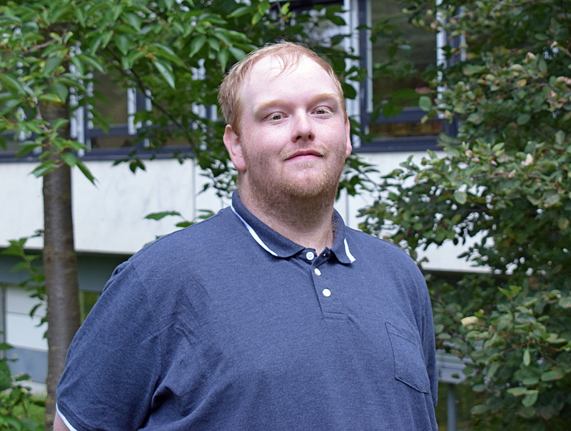 Porträtfoto von Daniel Bartels. Er trägt ein blaues Polo-Shirt.