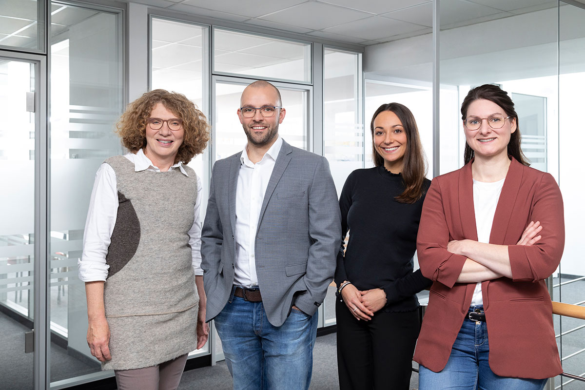 Vier Kolleginnen und Kollegen im Büro