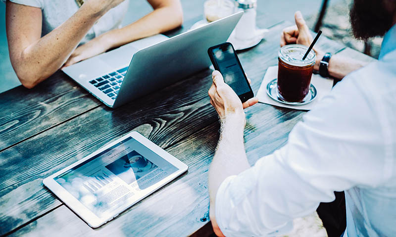 Business People Meeting Outside On Their Devices