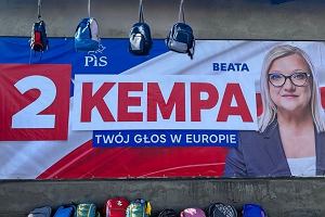 Bilboard wyborczy Beaty Kempy z PiS-u z plecakami przyniesionymi przez mieszkacw Kpna