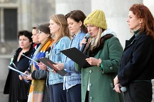 Monika Strzpka (w czapce) przed Teatrem Dramatycznym odczytuje ordzie w gecie solidarnoci z ofiarami rosyjskich atakw w Ukrainie. 24 marca 2022 r.