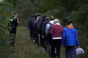 Grupa uchodcw kolumn kieruje si do miejsca, w ktrym kady zostanie przeszukany, oznaczony oraz odwieziony do orodka recepcyjnego.