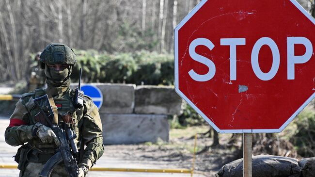 Военнослужащий ВС Белоруссии дежурит на КПП неподалеку от белорусско-украинской границы. Архивное фото