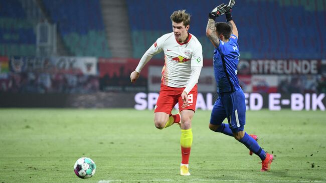 Leipzig's Norwegian forward Alexander Sorloth (L) and Augsburg's Polish goalkeeper Rafal Gikiewicz vie for the ball during the German first division Bundesliga football match between RB Leipzig and FC Augsburg in Leipzig, eastern Germany, on February 12, 2021. (Photo by ANNEGRET HILSE / POOL / AFP) / DFL REGULATIONS PROHIBIT ANY USE OF PHOTOGRAPHS AS IMAGE SEQUENCES AND/OR QUASI-VIDEO