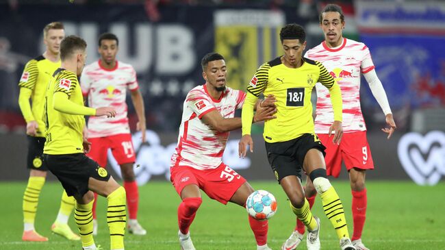 Leipzig's German defender Benjamin Henrichs (3rdR), Dortmund's English midfielder Jude Bellingham (2ndR) vie for the ball during the German first division Bundesliga football match between RB Leipzig and Borussia Dortmund in Leipzig, eastern Germany, on November 6, 2021. (Photo by Ronny HARTMANN / AFP) / DFL REGULATIONS PROHIBIT ANY USE OF PHOTOGRAPHS AS IMAGE SEQUENCES AND/OR QUASI-VIDEO