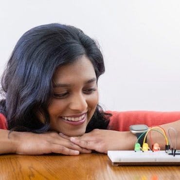 Headshot of Shree Bose looking at a breadboard