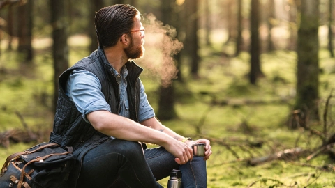 Ein Mann sitzt in einem Wald.