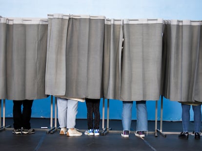 Varias personas ejercen su derecho al voto en el pabellón polideportivo Ames en A Coruña, este domingo.