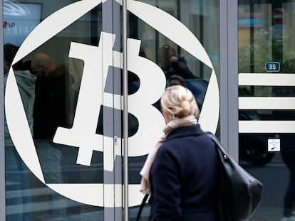 Una mujer, frente al banco La Maison du Bitcoin en 2017 en París.  (Photo by Chesnot/Getty Images)