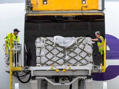 Dos operarios desembarcan la carga del segundo avión fletado, el 25 de mayo en el aeropuerto de Dulles (Virginia).