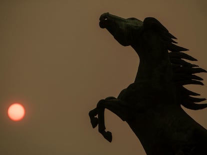 Vista del cielo cubierto de humo, con el sol enrojecido, en la plaza de España de Vigo.