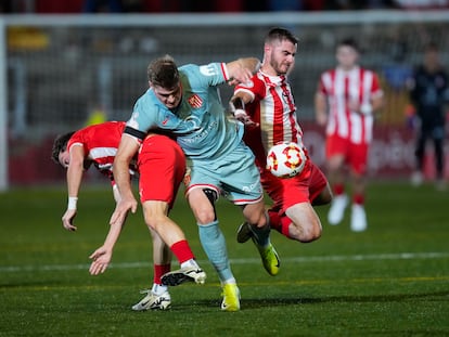 El delantero del Atlético de Madrid Alexander Sørloth (c) en acción ante la defensa del Vic este jueves, en un partido de primera ronda de la Copa del Rey, en Vic (Cataluña).