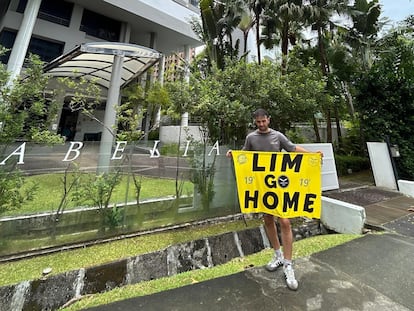 El aficionado del Valencia, retenido en Singapur, muestra una pancarta contra el dueño del club frente a una de sus propiedades en una imagen difundida en su cuenta de X y en otras informativas.