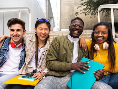 Un grupo de estudiantes de distintos países posan en las escaleras de un edificio en su campus universitario.