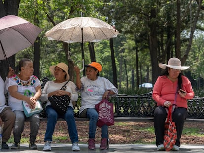 Personas se protegen de las altas temperaturas en la Alameda Central, en Ciudad de México, en junio de 2023.