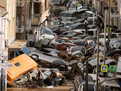 Vehículos amontonados en una calle tras las intensas lluvias de la dana, este miércoles en Sedaví (Valencia).