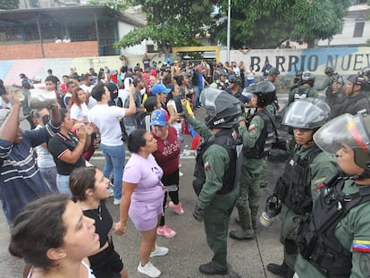 Un grupo de manifestantes protestan ante agentes de la Guardia Nacional Bolivariana.