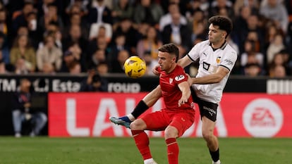 El centrocampista del Valencia Fran Pérez (d) disputa un balón con Adrià Pedrosa, defensa del Sevilla, durante el partido de la jornada 25 de LaLiga.