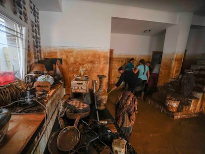 Un grupo de personas comienzan a limpiar su casa tras quedar anegada, este miércoles.