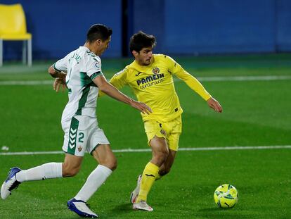 Gerard Moreno protege el balón ante el defensa del Elche Diego González este domingo en La Cerámica.