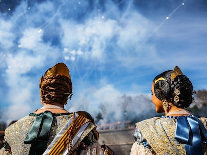 Dos falleras disfrutan de la 'mascletà' celebrada este domingo en Madrid Rio.