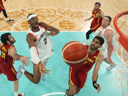 El canadiense Shai Gilgeous-Alexander, en acción ante Alex Abrines y Santi Aldama, con Rudy Fernández en el fondo de la imagen.