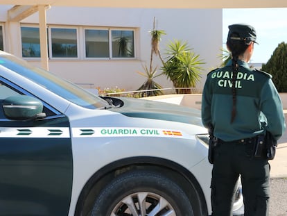 Agente de la Guardia Civil junto a un vehículo.