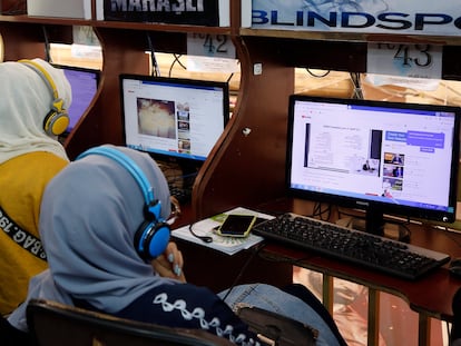 Dos mujeres yemeníes en un cibercafé en Saná, después de que internet fuera restablecido tras cuatro días de corte debido a ataques aéreos, en enero de 2022.