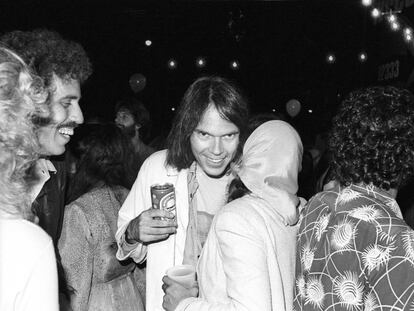 Neil Young, con una lata de cerveza en la mano, hablando con la cantante Nicolette Larson en la presentación de la película y disco 'Rust never sleeps' (donde se incluye 'Hey hey, my my (into the black)'. La fiesta fue en agosto de 1979 en Los Ángeles.