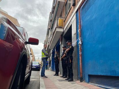 Los policías vigilan la puerta del inmueble en el que vivía Juana Canal antes de la desaparición.