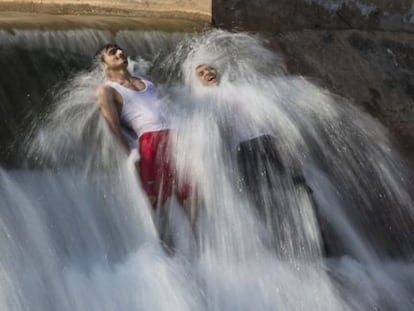 Dos hombres se bañan para combatir el calor en las afueras de Islamabad, Pakistán.