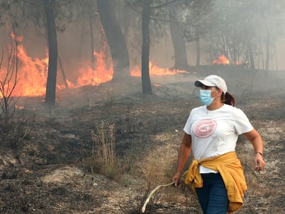 SANTIAGO DE CASSURRAES (PORTUGAL), 18/09/2024.-En algunas zonas, por falta de bomberos que estan en otros parajes en llamas, los vecinos de estos pueblos se han tenido que organizar para que las llamas no lleguen a los cascos urbanos. Es el caso de Elisabete Pinto (c), que ha acudido para ayudar. EFE/ Carlos García
