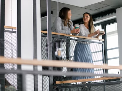 Dos mujeres toman café durante un descanso en el trabajo.