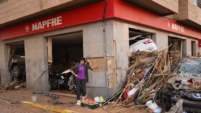 Una mujer pasa este jueves por delante de la oficina de una aseguradora arrasada por la dana en Paiporta (Valencia).