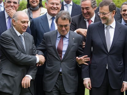 Artur Mas, entre Jorge Fernández Díaz (a la izquierda) y Mariano Rajoy, en mayo de 2013, cuando el primero era presidente de la Generalitat catalana, el segundo ministro del Interior y el tercero presidente del Gobierno.