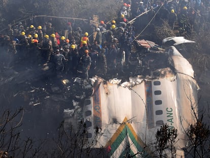 Personal de rescate trabajan junto a los restos del avión siniestrado en Pokhara, este domingo.