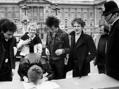 Así se las gastaban Sex Pistols. El grupo firma un contrato discográfico en la calle, a las puertas del Buckingham Palace en Londres. De izquierda a derecha, Johnny Rotten (voz), Steve Jones (guitarra, firmando), Paul Cook (batería), Syd Vicious (bajo) y el cerebro de todo, el mánager Malcolm McLaren. Un policía londinense vigila que la cosa no se salga de madre. Fue el uno de junio de 1977.