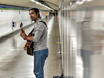 Kishan Adhikari toca la guitarra en el metro de Madrid.