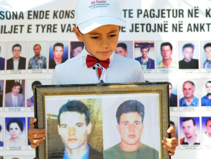 Un niño con las imágenes de dos desaparecidos durante la conmemoración del Día Internacional de los Desaparecidos, en agosto de 2019 en Pristina.