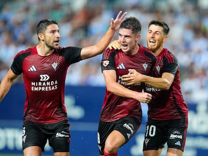 El jugador del Mirandés Joaquin Panichelli (centro) celebra un gol contra el Málaga en La Rosaleda junto a Tachi (izquierda) y Alberto Reina (derecha) el 24 de agosto.